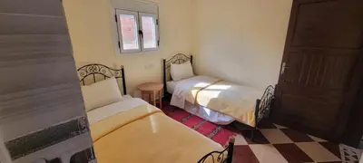 a small room with two beds and a window at Auberge l' avenir in Imilchil