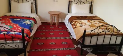 two beds sitting next to each other in a room at Auberge l'avenir in Imilchil