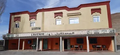 an old building with chairs in front of it at Auberge l'avenir in Imilchil