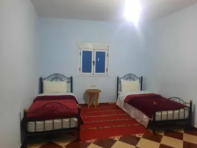 a room with two beds and a window at Auberge l'avenir in Imilchil