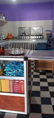 a kitchen with a counter and a table with books at Auberge l'avenir in Imilchil