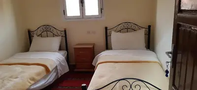 a bedroom with two beds and a window at Auberge l'avenir in Imilchil