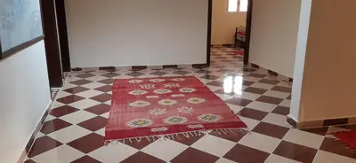 a hallway with a red rug on a checkered floor at Auberge l'avenir in Imilchil