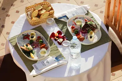 a table with three plates of food and a basket of bread at Maison D'hôtes IMINIGRAN & Spa in Ouarzazate