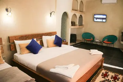 a bedroom with a large bed with blue pillows at Maison D'hôtes IMINIGRAN & Spa in Ouarzazate