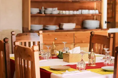a dining table with plates and glasses on it at Maison D'hôtes IMINIGRAN & Spa in Ouarzazate