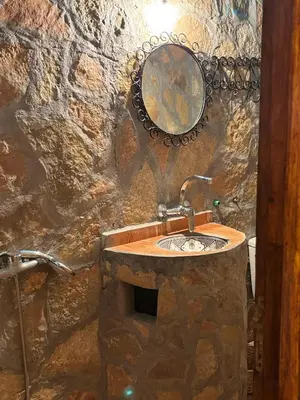 a stone bathroom with a sink and a mirror at Auberge restaurant Afoud in Agoudal