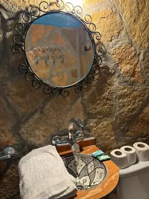 a bathroom with a sink and a mirror and towels at Auberge restaurant Afoud in Agoudal