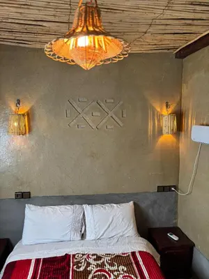 a bedroom with a bed and a chandelier at Auberge restaurant Afoud in Agoudal