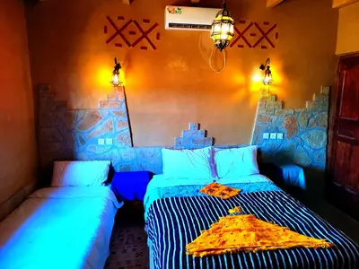 a bedroom with two beds with a pizza on it at Auberge restaurant Afoud in Agoudal