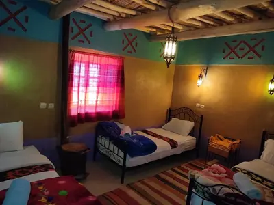 a small room with two beds and a window at Auberge restaurant Afoud in Agoudal