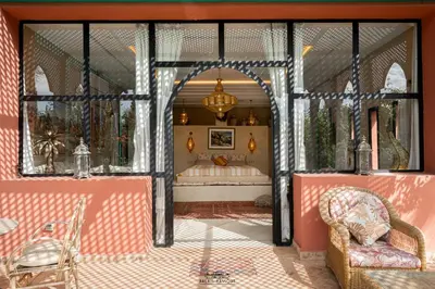a room with a bed and a table and chairs at Palais Hassoun Marrakech in Oulad Snaguia
