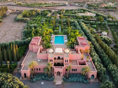 an aerial view of a pink mansion with a swimming pool at Palais Hassoun Marrakech in Oulad Snaguia
