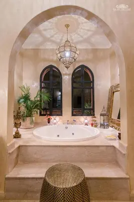 a large bathroom with a tub and a chandelier at Palais Hassoun Marrakech in Oulad Snaguia