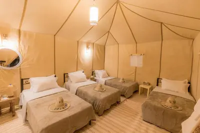 a room with three beds in a tent at Merzouga Heart Luxury Camp in Merzouga