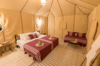 a bedroom with a bed in a tent at Merzouga Heart Luxury Camp in Merzouga