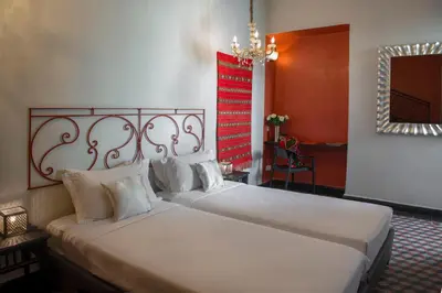 a bedroom with two beds and a chandelier at Riad Palais Bahia Fes in Fès