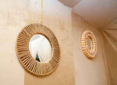 a mirror hanging on a wall next to a wall at Taghit Sahara Camp in Merzouga