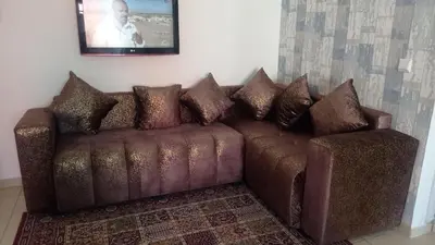 a brown couch with pillows in a living room at maison Halima in Ifrane