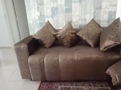 a brown couch with pillows on it in a room at maison Halima in Ifrane