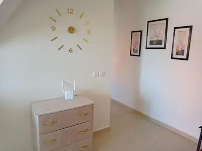 a clock on a wall above a dresser in a room at maison Halima in Ifrane