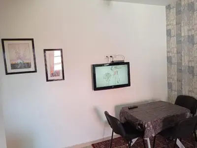a dining room with a table and some pictures on the wall at maison Halima in Ifrane