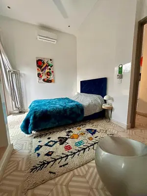 a bedroom with a bed and a rug at Villa Roswell Marrakech in Marrakech