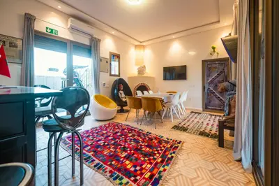 a living room with a table and chairs and a rug at Villa Roswell Marrakech in Marrakech