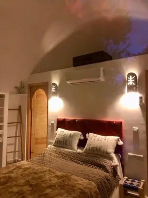 a bedroom with a bed with two pillows and two lights at Villa Roswell Marrakech in Marrakech