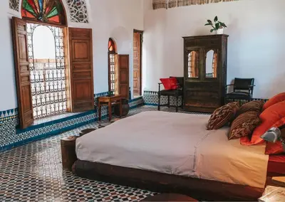 a bedroom with a bed and a chair and a window at Riad 9 Fez in Fès