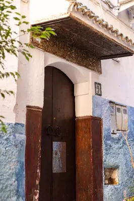 a door to a house with a blue and white wall at Riad 9 Fez in Fès