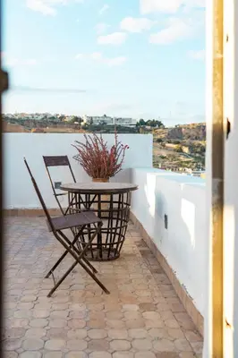 a table and chair on a balcony with a view at Riad 9 Fez in Fès