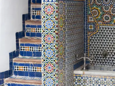 a bathroom with a shower with blue and white tiles at Riad 9 Fez in Fès