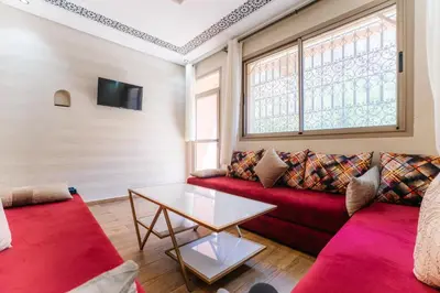 a living room with a red couch and a table at The best apartments of Ourika valley in Setti Fatma