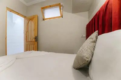 a bedroom with a bed with a red headboard and a window at The best apartments of Ourika valley in Setti Fatma