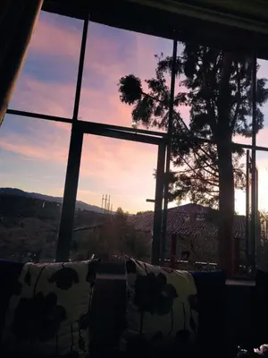 a view of the sunset from a living room window at La belle vue Elmazini in Demnat