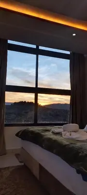 a bed in a room with a large window at La belle vue Elmazini in Demnat