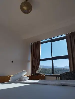 a bedroom with a bed with a large window at La belle vue Elmazini in Demnat