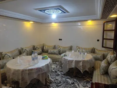 two tables in a room with couches and chairs at La belle vue Elmazini in Demnat