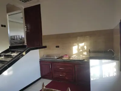 a kitchen with wooden cabinets and a counter top at La belle vue Elmazini in Demnat