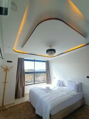 a bedroom with a large bed with a large window at La belle vue Elmazini in Demnat