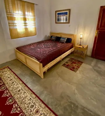 a bedroom with a large bed in a room with rugs at Les chandelles in Tinerhir