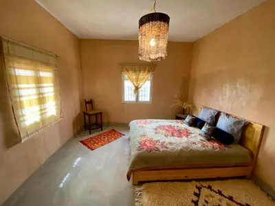 a bedroom with a bed and a chandelier at Les chandelles in Tinerhir