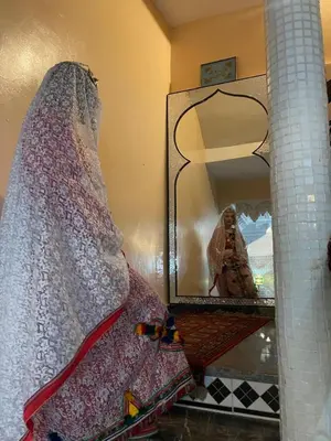 a bedroom with a bed and a mirror at Riad Dar Fadma in Ouarzazate