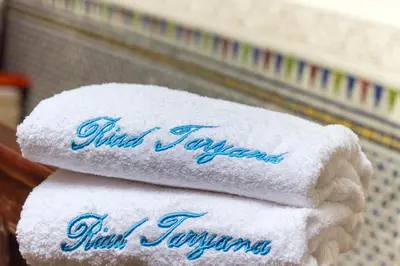 three towels stacked on top of each other on a shelf at Riad Taryana in Fès