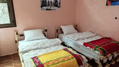 two twin beds in a room with at auberge gite de jeunesse les Cascades in Setti Fatma