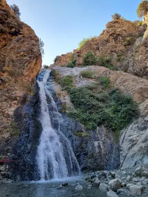 a waterfall on the side of a rocky mountain at auberge gite de jeunesse les Cascades in Setti Fatma
