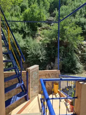 a set of stairs with blue railings on a house at auberge gite de jeunesse les Cascades in Setti Fatma