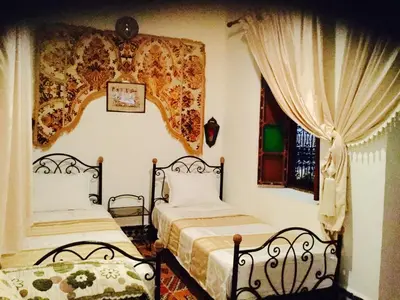 a bedroom with two beds and a window at Dar Hafsa in Fès