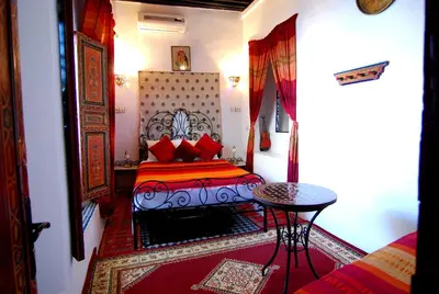 a small bedroom with a bed and a table at Dar Hafsa in Fès